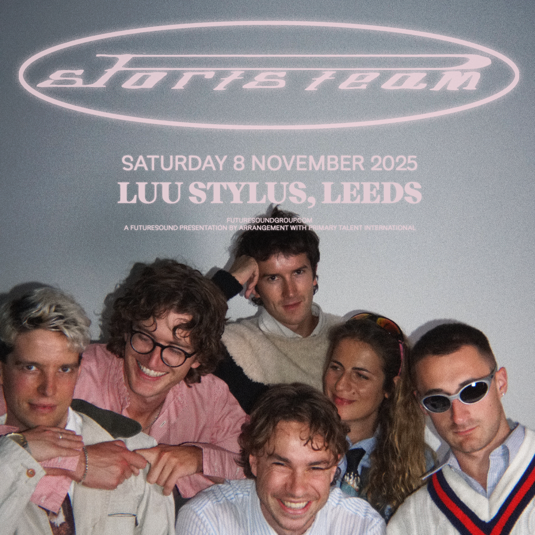 Tour poster for the band Sports Team. The band name appears at the top in a stylized, futuristic pink font enclosed in an oval outline. Below, text reads 'Saturday 8 November 2025, LUU Stylus, Leeds' in bold pink letters. The bottom includes the website 'futuresoundgroup.com' and mentions the show is presented by Futuresound in arrangement with Primary Talent International. The band members are pictured below the text, smiling and posing casually against a plain backdrop, dressed in a mix of preppy and retro clothing.