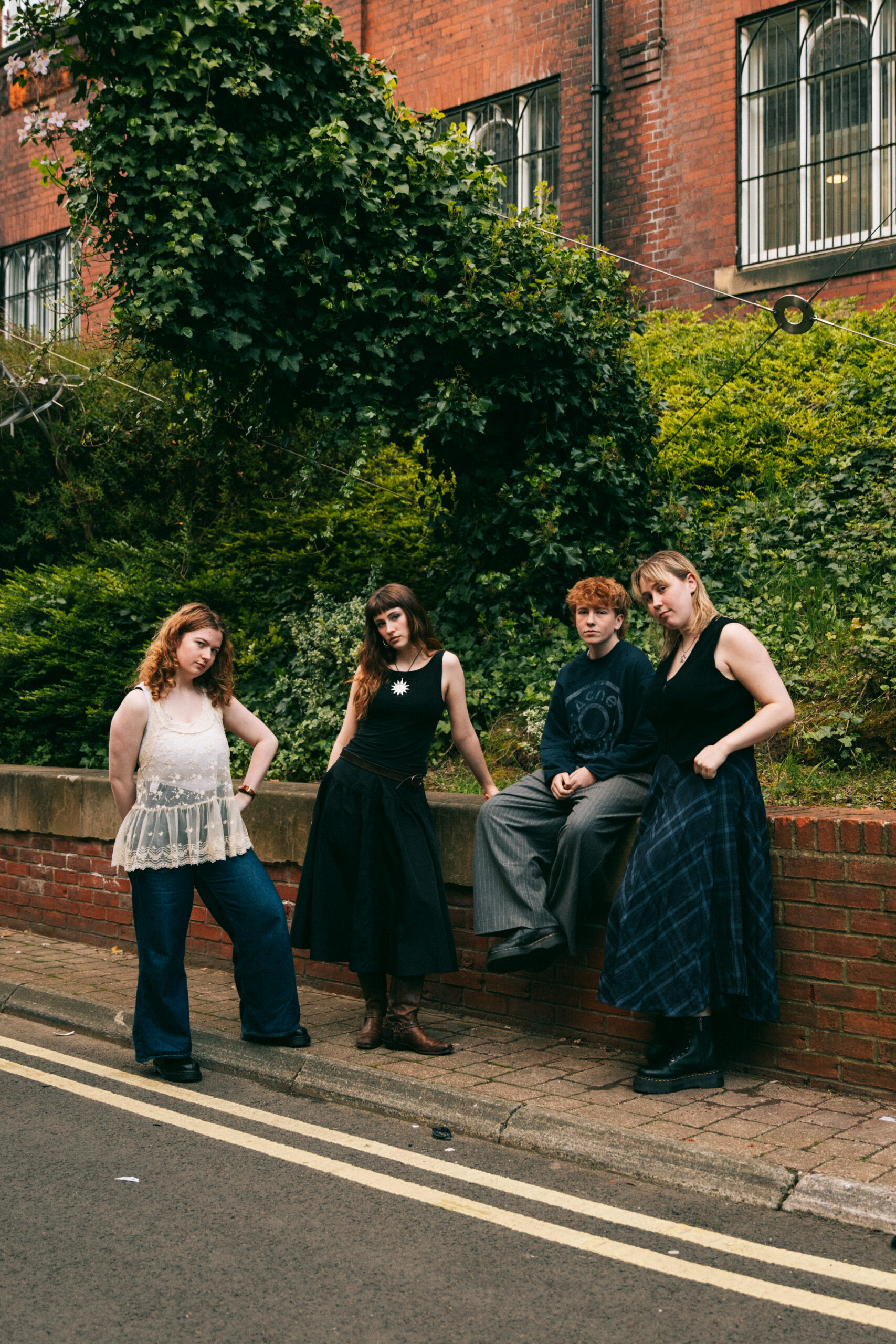 Four young women posing on a brick wall on Florence Road